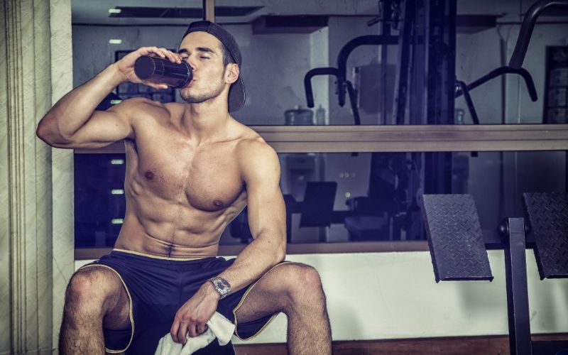 supplement store-shirtless-young-man-drinking-protein-shake-in-gym-86058676-min