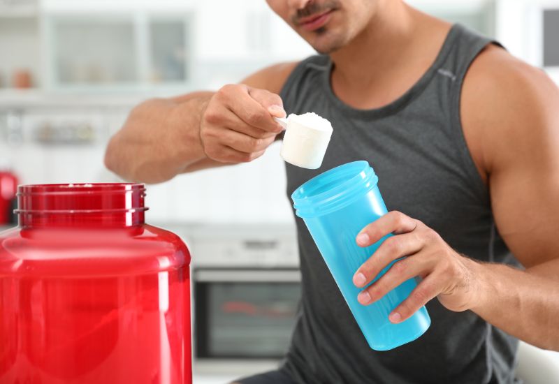 powder-for-gym-young-athletic-man-preparing-protein-shake-in-kitchen--min