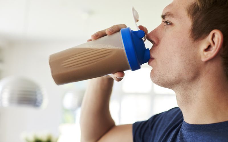 proteins-powder-man-drinking-shake-at-home-min