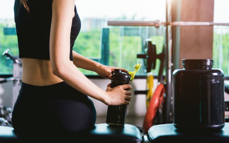 proteins-powder-woman-making-shake-at-the-gym-min