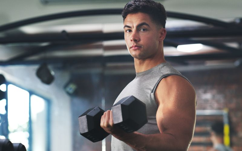 best-whey-protein-south-africa-bulking-up-and-building-muscle-portrait-of-a-sporty-young-man-exercising-with-a-dumbbell-at-the-gym (1)-min