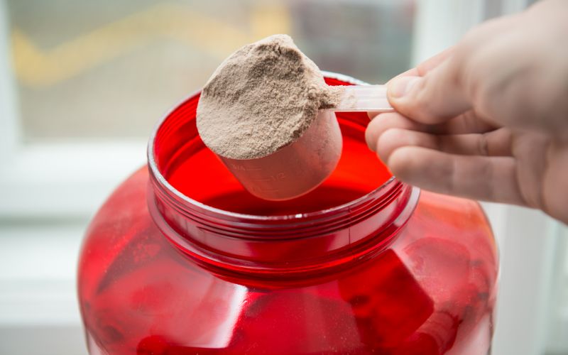 gym-powder-man-taking-scoop-powder-out-of-container-min