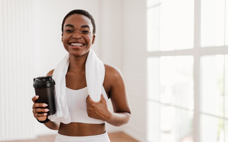 best-whey-protein-south-africa-portrait-of-sporty-beautiful-smiling-black-woman-in-white-sportswear-min