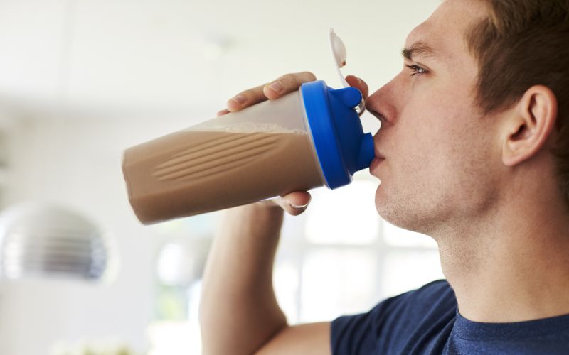 NPL-Whey-Protein-man-drinking-protein-shake-in-kitchen-at-home-min