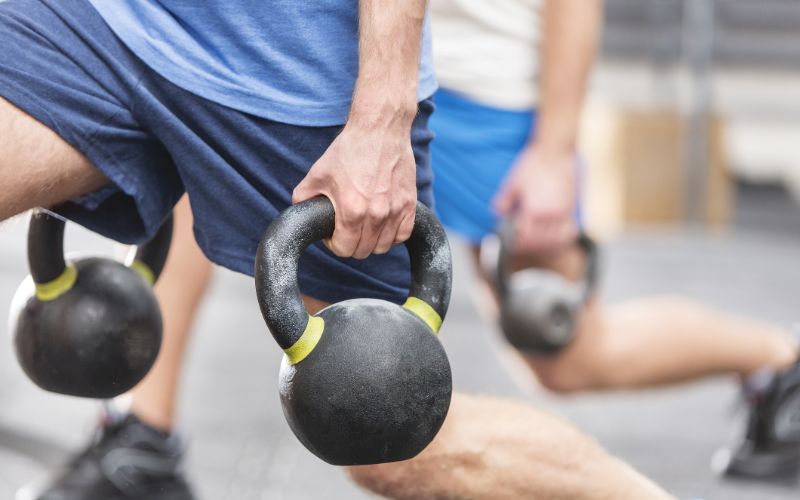 best-whey-protein-south-africa-cropped-image-of-men-lifting-kettlebells-min