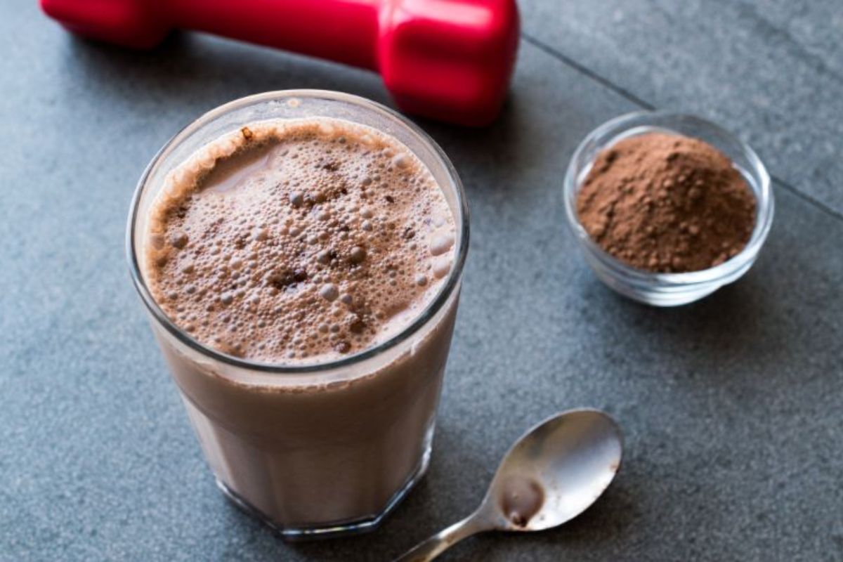 (best-whey-protein-south-africa)-chocolate-protein-shake-smoothie-with-whey-protein-powder-and-red-dumbbells-min