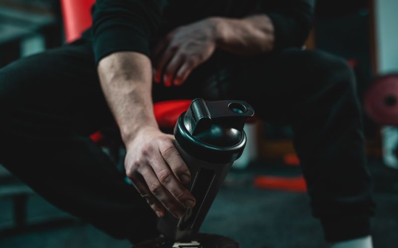 npl supplements-close-up-of-man-sitting-on-workout-bench-min