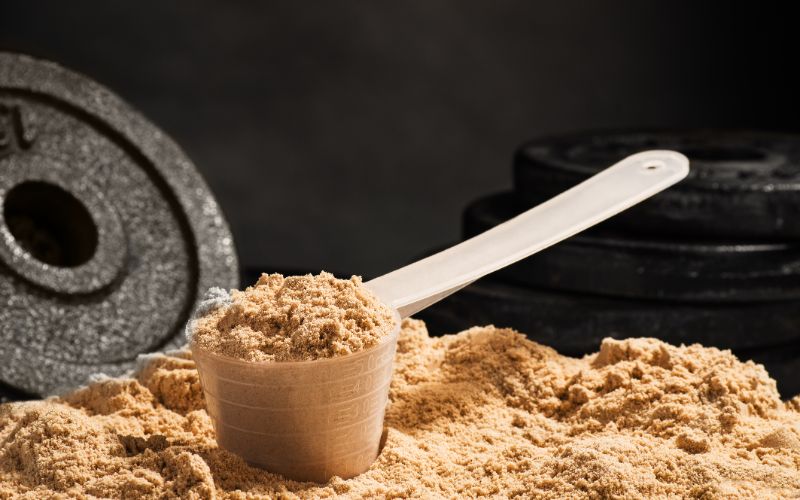 best-whey-protein-south-africa-scoop-of-whey-protein-with-weights-min