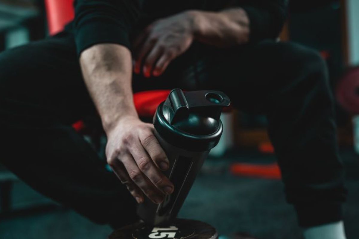 close-up-on-hand-of-unknown-caucasian-man-holding-dark-supplement-shaker-while-sitting-at-gym-during-training-copy-space-selective-240901206-min (1)