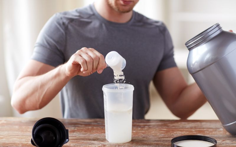 npl-supplements-close-up-of-man-with-protein-shake-bottle-and-jar-min